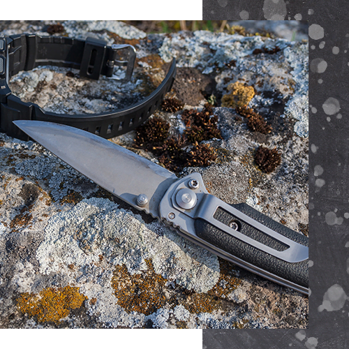 PSDimage Knife resting on a rocky surface with a black wristband, symbolizing self-defense tools and strategies discussed in martial arts training.